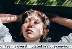 Person feeling overstimulated in a busy environment